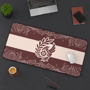 Può includere: Un tappetino per mouse da gioco marrone e bianco con un design di uccello stilizzato e motivi intricati. Il design presenta un uccello con un'ala distesa, circondato da foglie e un motivo geometrico. Il tappetino per mouse ha una striscia bianca al centro.