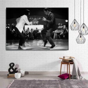 Pode incluir: Uma impressão de arte de parede em preto e branco retratando duas pessoas dançando em um palco. Uma pessoa veste um blazer claro e calças escuras, enquanto a outra veste um terno escuro. A cena ocorre em uma sala pouco iluminada com um bar.
