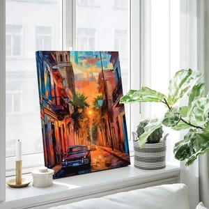 a painting on a window sill next to a potted plant