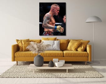 May include: A rectangular wall art print featuring a side profile of a shirtless mixed martial arts fighter with extensive arm tattoos, wearing gold and blue UFC gloves, with visible blood on the face and nose, displayed in a modern interior.