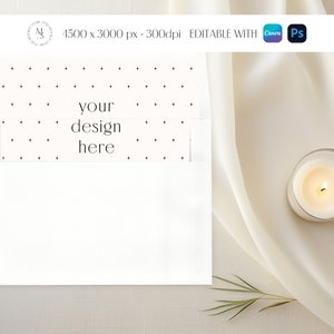 May include: A white envelope with a dotted pattern and the text "your design here" on the front. The envelope is lying on a white surface with a white candle and a green sprig.