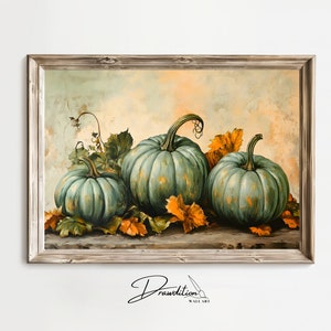 May include: A framed painting of three green pumpkins with orange leaves on a brown surface. The pumpkins are arranged in a row, with the largest pumpkin in the center. The painting has a vintage feel and is signed "Drawdition Wall Art".