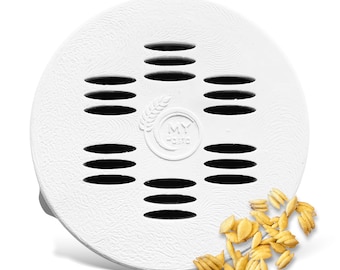 May include: A white, round pasta drying rack with multiple horizontal slots. The rack has a textured surface and the words "MY Taste" are printed on the center. A small pile of dried pasta is next to the rack.
