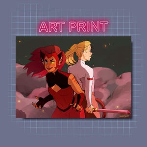 Op de afbeelding: Een kunstprint met twee vrouwelijke personages uit de animatieserie She-Ra en de Prinsessen van de Macht. Het personage links is Adora, die een rood-zwart kostuum draagt met een kattenachtige hoofdtooi. Het personage rechts is Catra, die een wit-roze kostuum draagt. De achtergrond is een roze-paarse lucht met sterren.