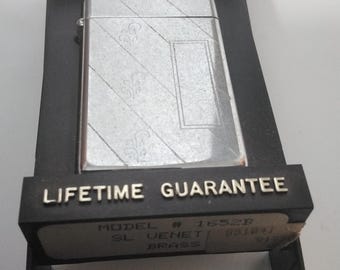 Encendedor Zippo plateado con diseño en estuche