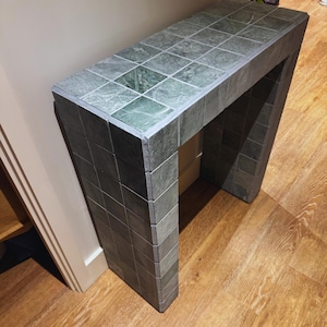 Puede incluir: Un letrero de madera rústico con el texto "Welcome to our home" en letras blancas. El letrero presenta un acabado envejecido y un diseño simple y acogedor, perfecto para la decoración de la puerta principal.