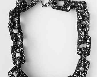 A handmade chunky acrylic/plastic black white dotty/pattern rectangle link necklace with toggle clasp