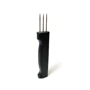 May include: A black plastic tool with three metal prongs. The tool is used for tenderizing meat.