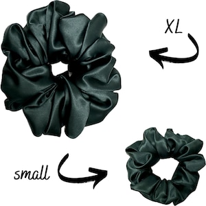 May include: Two dark green satin scrunchies, one large and one small. The larger scrunchie is labeled "XL" and the smaller scrunchie is labeled "small".
