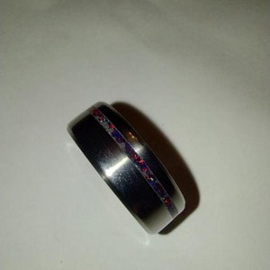 May include: A silver ring with a thin band and a red and blue inlay.