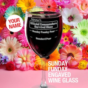 May include: A clear wine glass filled with red liquid, featuring engraved text: "Megan's Official Commanders Survival Glass - Sunday Funday Pour - Standard Pour." The glass is surrounded by colourful flowers on a pink background. Text at the bottom reads "Sunday Funday Engraved Wine Glass."