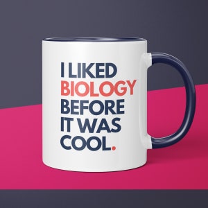 May include: White ceramic mug with a blue rim and handle. The mug has the text "I LIKED BIOLOGY BEFORE IT WAS COOL." printed in blue and red.
