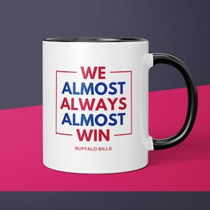 May include: White ceramic coffee mug with a black handle. The mug has a red and blue graphic that says "WE ALMOST ALWAYS ALMOST WIN" with the words "BUFFALO BILLS" below the graphic.