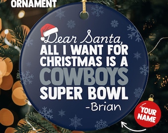 May include: A navy blue Christmas ornament with the text "Dear Santa, ALL I WANT FOR CHRISTMAS IS A COWBOYS SUPER BOWL -Brian". The ornament has a Santa hat graphic and snowflake designs. A red circle says "YOUR NAME".