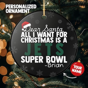 May include: A black personalized Christmas ornament with the text "Dear Santa, All I Want For Christmas Is A Jets Super Bowl -Brian". The ornament has a red Santa hat graphic and snowflakes.