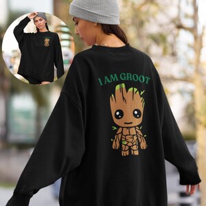 May include: Black sweatshirt with a green and brown cartoon character on the back. The character is a humanoid tree with the text "I AM GROOT" above it.