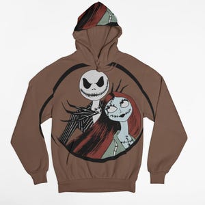 May include: A brown hooded sweatshirt with a graphic print of Jack Skellington and Sally from the Nightmare Before Christmas movie. The print is in a circle with a black outline.