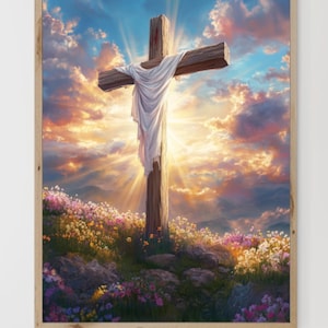 Op de afbeelding: Een houten kruis met een witte doek eroverheen staat op een heuveltop met een heldere, kleurrijke zonsondergang op de achtergrond. Het kruis is omringd door wilde bloemen.