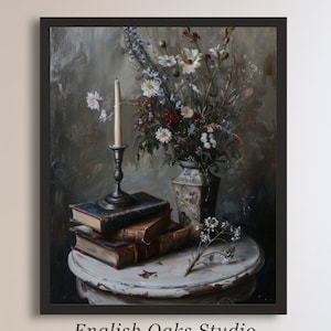 May include: A still life painting of a bouquet of white and red flowers in a vase, a stack of books, and a candle on a white table. The painting is framed in black.