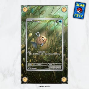 Puede incluir: Una carta Pokémon Feebas en una funda protectora, con una ilustración de pez marrón y azul sobre un fondo acuático verde. La carta está etiquetada como "Feebas" con un símbolo "30". Una pegatina "SLAB CITY" es visible.