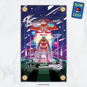 May include: A Deoxys VMAX Pokemon card, encased in a protective holder. The card features a colorful illustration of a Deoxys character with the text "VMAX" and "Protective DNA". A "SLAB CITY" sticker is in the upper right corner.