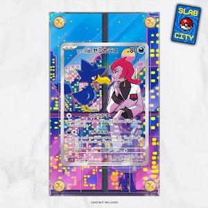 May include: A Pokémon trading card featuring a blue bird-like creature and a woman with pink hair, set against a cityscape backdrop. The card is encased in a clear protective holder with gold-colored screws. A small "SLAB CITY" sticker is in the upper right corner.