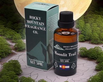 May include: A brown glass bottle and a matching box of Rocky Mountain Fragrance Co. essential oil. The bottle is labeled "Moonlit Trail" and contains 50ml of fragrance. The box features the company logo and the words "Fragrance Adventure".