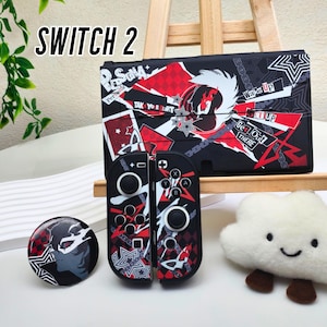Peut inclure: Un étui, des manettes et des accessoires noirs pour Nintendo Switch 2, avec un motif graphique rouge et blanc. Le motif comprend du texte qui dit "Persona", "Wake Up" et "Get Out There". Une peluche nuage blanche est également dans l'image.
