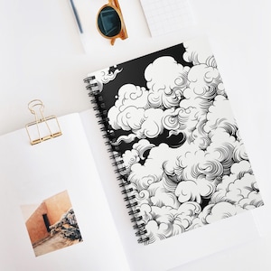 May include: A black and white spiral notebook with a design of swirling clouds. The clouds are drawn in a detailed, intricate style.