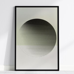 May include: A framed wall art print featuring a large black circle composed of horizontal lines of varying thickness. The circle is centred against a split background of light grey on the top half and a muted sage green on the bottom half.