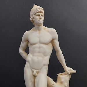 以下が含まれることがあります： 長方形の台座に立つ、裸の男性像の古典的なスタイルの彫刻。 この像は薄いベージュ色で彫刻されており、ヘルメットとひげがあります。 この像は木の幹に寄りかかっています。