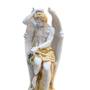 May include: White statue of an angel with wings, sitting with a chain around its wrists and ankles. The angel is holding its head in its hand and has a sorrowful expression. The chain and parts of the statue are painted gold.