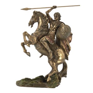 May include: A bronze-colored statue of a man on horseback, holding a spear aloft. The horse rears up, and the man holds a shield. The statue has a detailed design and sits on a green base.