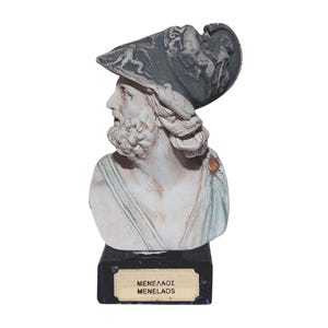 May include: A classical bust of a man with a beard and a helmet. The bust is white with grey and blue accents. The base is black with a gold nameplate that reads "MENELAOS" and "MENELAOS".