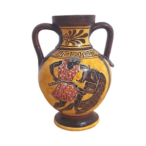 Puede incluir: Una ánfora de cerámica amarilla y marrón con una escena pintada en negro y rojo de una figura luchando contra una bestia. La ánfora tiene dos asas y un diseño geométrico alrededor del medio.