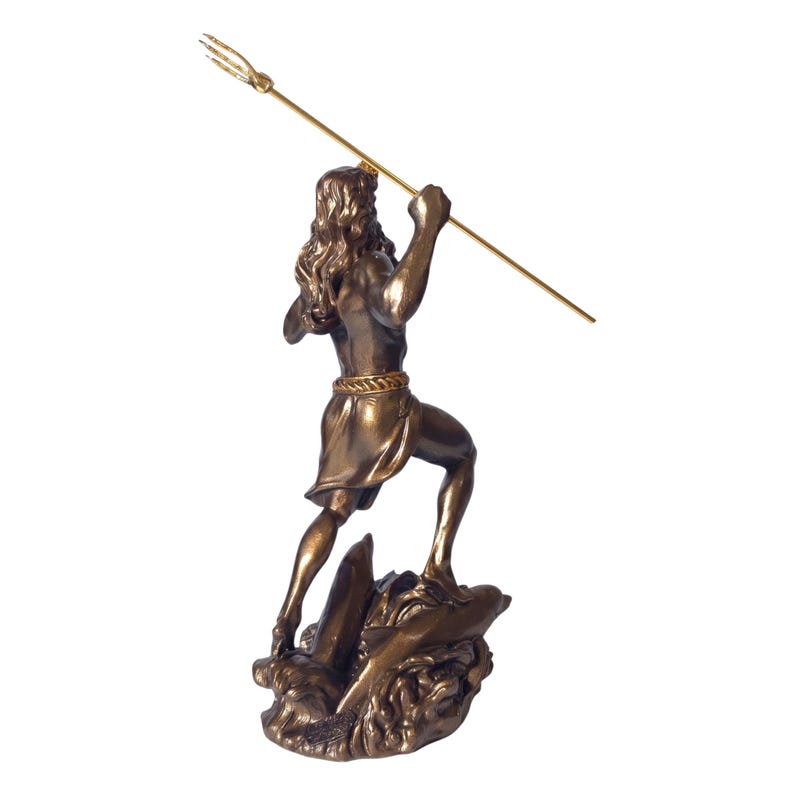 May include: A bronze-coloured statue of a man holding a golden trident, standing on a rocky base. The figure has long hair and is wearing a short tunic. The statue is a decorative item.