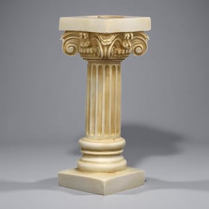 May include: A cream-colored, classical-style pedestal with a square base and top. The column features fluted detailing and ornate scrollwork at the capital. This decorative piece is suitable for displaying sculptures or plants.
