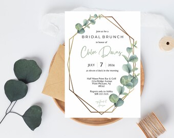 May include: A white invitation with a gold geometric frame and green eucalyptus leaves. The invitation reads "Join us for a Bridal Brunch in honor of Chloe Downs, July 7, 2024, at eleven o'clock in the morning. Half Moon Point Bar & Grill, 2154 Bridge Avenue, Point Pleasant, NJ 08742. Regrets only to Ashley 908 222 2121. Registered at Aruga."