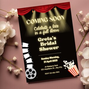 May include: A black and red movie-themed bridal shower invitation with a red curtain, spotlights, and a film reel. The text reads "Coming Soon, Celebrate a love in a full bloom, Greta's Bridal Shower, Sunday Morning, 21 April 2025, At Rimberio Park, 123 Anywhere St., Any City, RSVP: 123-456-7890".