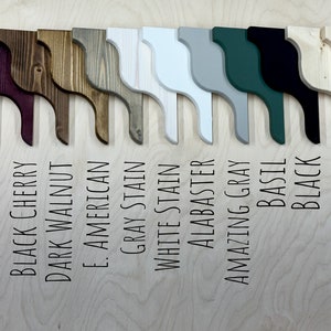 Puede incluir: Una fila de 12 soportes de estanter&iacute;a de madera en varios colores de tinte, incluyendo tinte de &eacute;bano, cerezo negro, nogal oscuro, americano, tinte gris, tinte blanco, alabastro, gris asombroso, albahaca, negro, capa transparente y sin terminar.