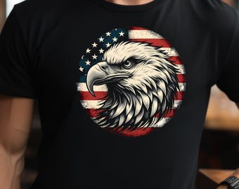 Puede incluir: Una camiseta negra con un gráfico de la cabeza de un águila calva frente a una bandera estadounidense.