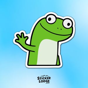 May include: A green frog sticker with a white outline, waving its hand. The frog has large, round eyes and a smiling expression. The sticker has the text "STICKER LODGE .COM" at the bottom.