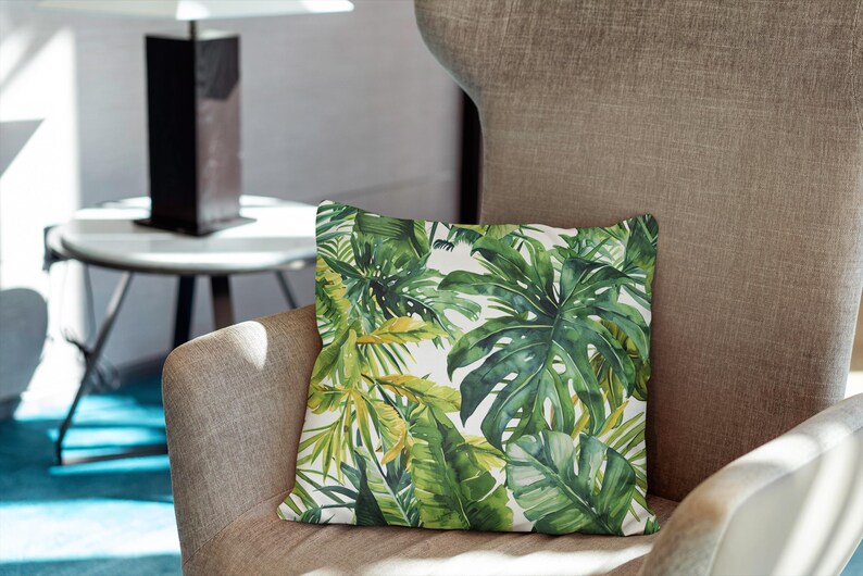 May include: A square throw pillow featuring a vibrant botanical print with various shades of green monstera and palm leaves set against a crisp white background, showcasing detailed foliage patterns across the entire surface.
