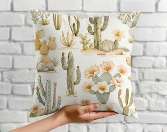 Puede incluir: Un cojín cuadrado con un patrón repetitivo de varios cactus y suculentas en tonos verdes y bronceados sobre un fondo blanco, incluyendo cactus saguaro altos, chumberas y varias flores en flor de color amarillo pálido.