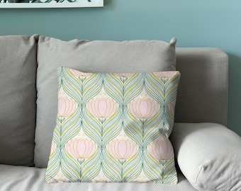Puede incluir: Un cojín cuadrado con un patrón repetitivo de flores estilizadas de color rosa, acompañadas de motivos de hojas curvas en amarillo claro y verde sobre un fondo blanco, delineado con finas líneas oscuras.
