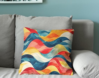 Puede incluir: Un cojín cuadrado con un patrón abstracto y vibrante de ondas fluidas y ondulantes en tonos azul profundo, amarillo brillante y rojo cálido, acentuado con líneas finas y oscuras que siguen las curvas del diseño colorido.