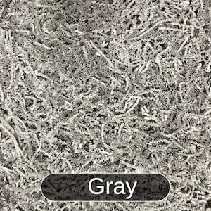 May include: Gray shredded paper filling a container. The paper is made of thin, crinkled strips.