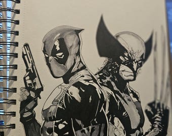 Op de afbeelding: Een zwart-wit inkttekening in een spiraalblok met Deadpool die een handvuurwapen vasthoudt en Wolverine met uitgestrekte klauwen, rug aan rug staand. De illustratie gebruikt contrastrijke arceringen om de maskers van de personages te definiëren.