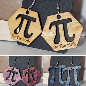 Puede incluir: Pendientes hexagonales de madera con el símbolo Pi recortado. Disponibles en madera natural, morado y azul. La frase "Do The Math" está grabada en cada pendiente. Ganchos plateados.