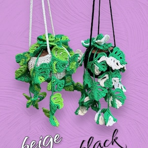 May include: Two crocheted hanging plant pots, one with a beige cord and the other with a black cord. Both pots are decorated with green and white crocheted leaves. The text "beige" and "black" is written below the pots.